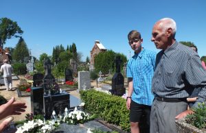 Gydytojo sūnus Antanas Gudonis prie tėvo kapo su vaikiačiais. A.Minkevičienės nuotr.