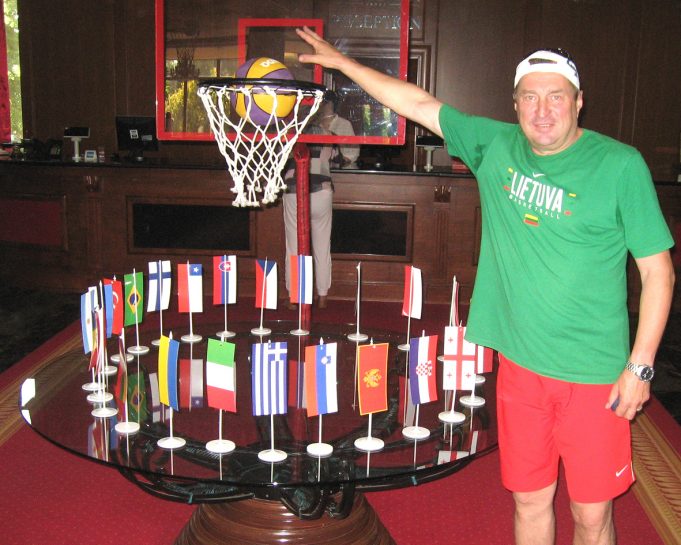 Žinomas rajono krepšinio entuziastas Gintaras Kravčenka – prie specialaus Europos veteranų krepšinio čempionato stendo su šalių-dalyvių vėliavomis. G. Kravčenkos archyvo nuotr.