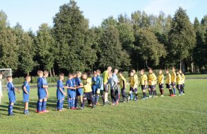 Pasisveikinimas su grėsmingu varžovu – Panevėžio futbolo akademijos antrąja komanda (šviesesnė apranga).
