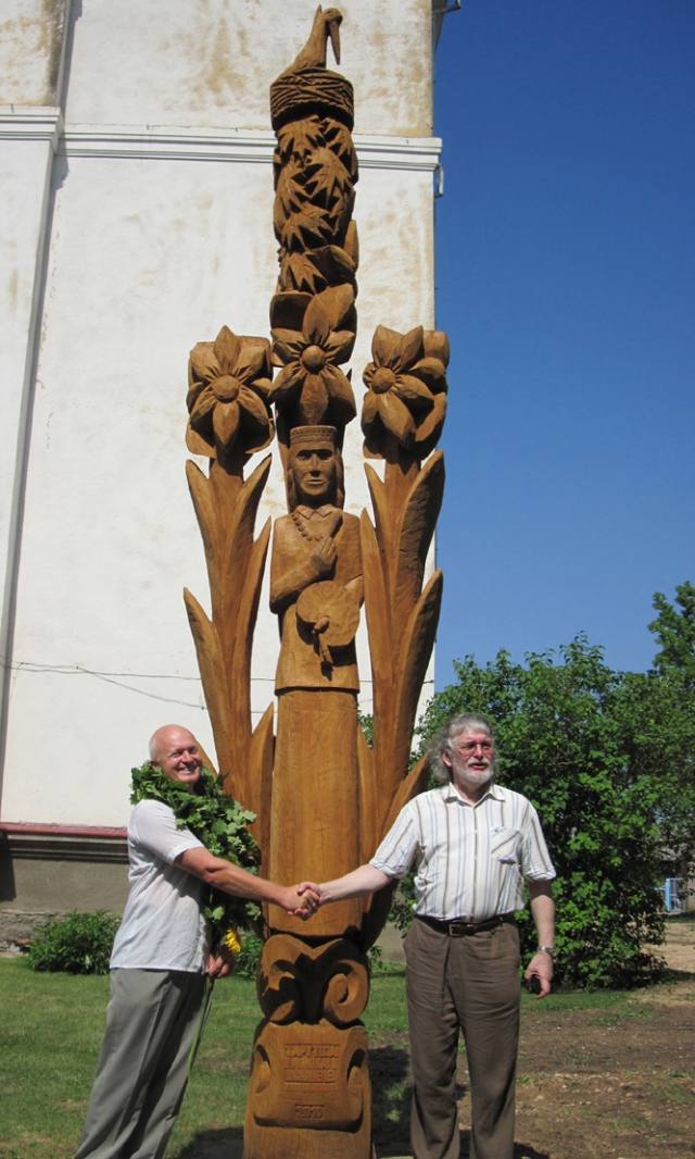 Prie menininkei M.Bičiūnienei skirtos medžio skulptūros įsiamžino  sūnus Rimas Bičiūnas (dešinėje) ir kūrinio autorius Almantas Sriubiškis. Rokiškio krašto muziejaus archyvo nuotr.