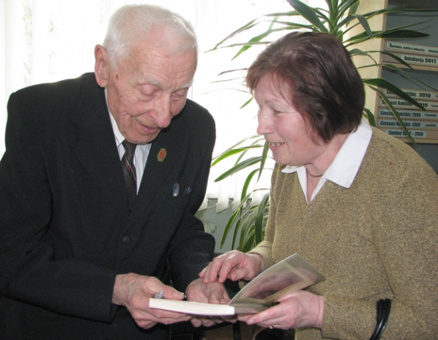 Feliksas Mažeikis savo knygą su autografu dovanojo Vidai Žegliūnienei. N.Byčkovskio nuotr.